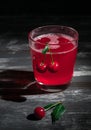 Cherry juice in a glass. Garnished with cherries. Dark wooden background. Hard light. Close-up Royalty Free Stock Photo