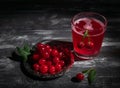 Cherry juice in a glass. Garnished with cherries. Dark wooden background. Next to a glass is a metal plate with cherry berries Royalty Free Stock Photo