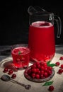 Cherry juice in a glass. Garnished with cherries. Dark wooden background. Next to a glass is a metal plate with cherry berries. In Royalty Free Stock Photo