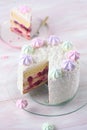 Cherry Layer Cake decorated with fine coconut flakes and colored meringue cookies Royalty Free Stock Photo
