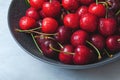 Cherry with leaf on plate and water dropsand on grey stone table. Ripe ripe cherries. Sweet red cherries. Top view. Royalty Free Stock Photo