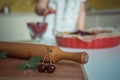 A cherry with leaves sitts near a rolling pin on the kitchen desk Royalty Free Stock Photo