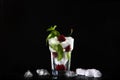 Cherry lemonade in a tall glass glass with ice. Photo on a black background. Seasonal summer drink. Photo on a black background. Royalty Free Stock Photo