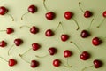 Cherry pattern. Flat lay of cherries and leaves on a blue background.Top view