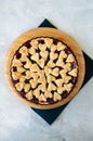 Cherry pie with heart shape decorations from flaky dough on a white backdrop Royalty Free Stock Photo