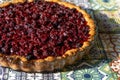 Cherry pie top view. Homemade baking. Round open tart with filling. Pouring pastries on the table of colored tiles Royalty Free Stock Photo