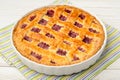 Cherry pie on white wooden table.