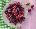 Cherry in a plate organic on a pink wooden background, towel Royalty Free Stock Photo