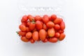 Cherry plum tomatoes in a plastic container on the table. Royalty Free Stock Photo