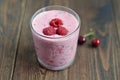 Cherry and Raspberry Smoothies in a Glass Cup. Fresh raspberries in it. Dark wooden table. Royalty Free Stock Photo
