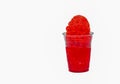 Cherry Red Hawaiian Shave ice, Shaved ice or snow cone in a clear cup against a white background.