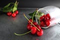 Cherry red ripe berry fell out of the glass on a black background with the est for the text. vitamins seasonal berry hemoglobin