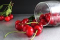 Cherry red ripe berry fell out of the glass on a black background with the est for the text. vitamins seasonal berry hemoglobin