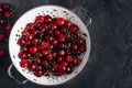 Cherry. Sweet Cherries in white colander on dark stone concrete background. Ripe Sweet Red Cherries Royalty Free Stock Photo