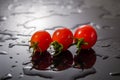 Cherry tomato on a black background with water Royalty Free Stock Photo