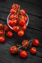 Cherry tomato branch, fresh ripe organic vegetables on dark black textured background, macro angle view Royalty Free Stock Photo