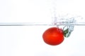 Cherry tomato falling into water with a splash Royalty Free Stock Photo