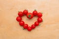 Cherry Tomato fresh in heart shape on wooden chopping board, flat lay