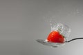 Cherry tomato with water's splash in a spoon