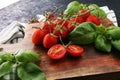 Cherry tomatoes with basil and dish towl on cutting board Royalty Free Stock Photo