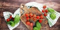 Cherry tomatoes with basil and dish towl on cutting board Royalty Free Stock Photo