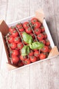 Cherry tomatoes and basil in a wooden box