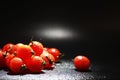 Cherry tomatoes on a black background in the spray Royalty Free Stock Photo
