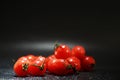 Cherry tomatoes on a black background in the spray Royalty Free Stock Photo