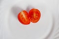 cherry tomatoes cut into two parts on a white Terence. close up. vegetarian healthy food. Royalty Free Stock Photo