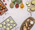 Cherry tomatoes on a cutting board, three kinds of seasoning in wooden spoons, sliced zucchini the grid for roasting, seasoning Royalty Free Stock Photo