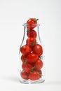 Cherry tomatoes in glass bottle over white Royalty Free Stock Photo