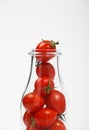 Cherry tomatoes in glass bottle over white Royalty Free Stock Photo