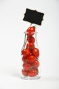 Cherry tomatoes in glass bottle over white Royalty Free Stock Photo