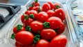Cherry tomatoes with green roots packed in plastic containers. Royalty Free Stock Photo