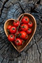 Cherry tomatoes in heart shape plate on old wooden surface, space for text Royalty Free Stock Photo