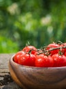 Cherry tomatoes in heart shape plate on old wooden surface, space for text Royalty Free Stock Photo