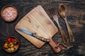 cherry tomatoes, knife and cutting board on a dark wooden table. View from above. Space for text