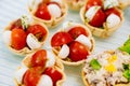 cherry tomatoes and mozzarella cheese in dough baskets.