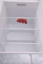 Cherry tomatoes in open empty refrigerator.