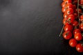 Cherry tomatoes over a black stone plate with copy space. Royalty Free Stock Photo