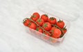 Cherry tomatoes in plastic container on the marble table texture Royalty Free Stock Photo