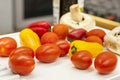 cherry tomatoes and small yellow and red bell peppers on a white grill plate Royalty Free Stock Photo