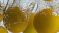 Cherry tomatoes splashing water closeup. Organic yellow vegetables falling in Royalty Free Stock Photo