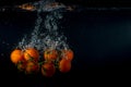 Cherry tomatoes in water splash on black Royalty Free Stock Photo