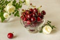 Cherry in a transparent plate. Near a bouquet of roses Royalty Free Stock Photo