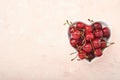 Cherry with water drops on heart shaped plate on white stone table. Fresh ripe cherries. Sweet red cherries. Top view. Rustic Royalty Free Stock Photo