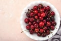 Cherry with water drops on white bowl on pink stone table. Fresh ripe cherries. Sweet red cherries. Top view. Rustic style. Fruit Royalty Free Stock Photo