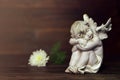 Cherub and white flower on dark background Royalty Free Stock Photo