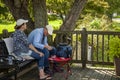 elderly caucasian couple playing cards outside