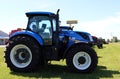 Large blue agricultural tractor on farm equipent dealership on a sunny summer day